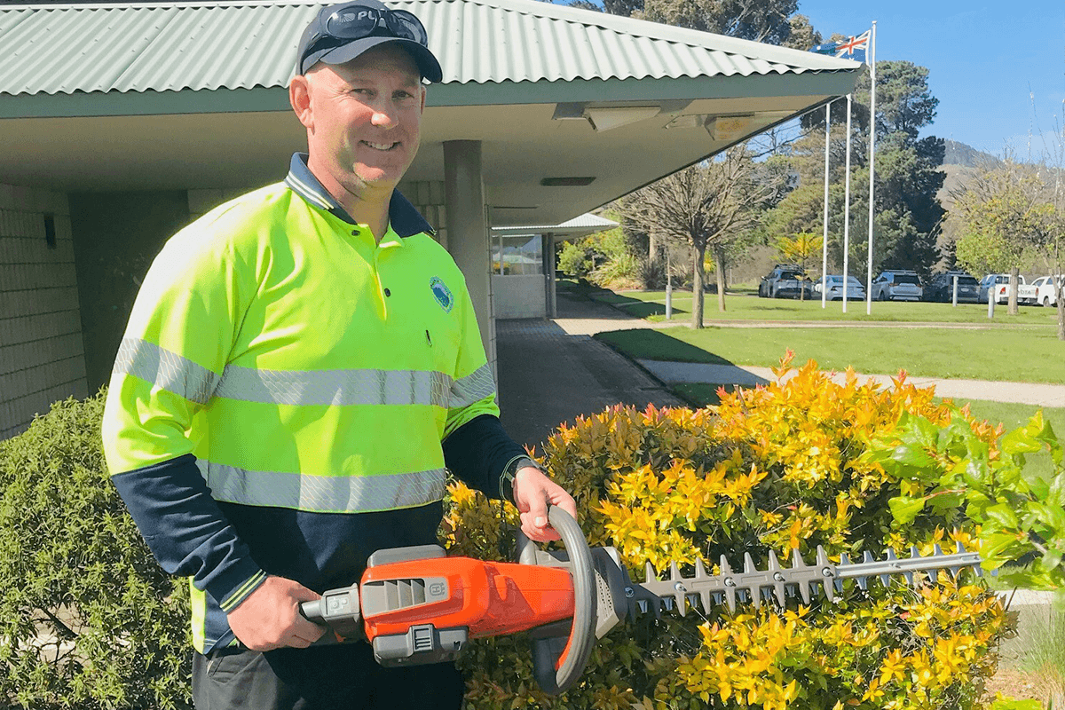 Man in high vis with hedge trimmer 