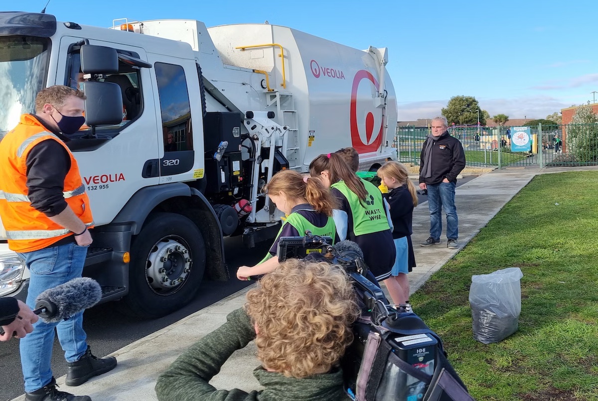 children in front of garbage truck